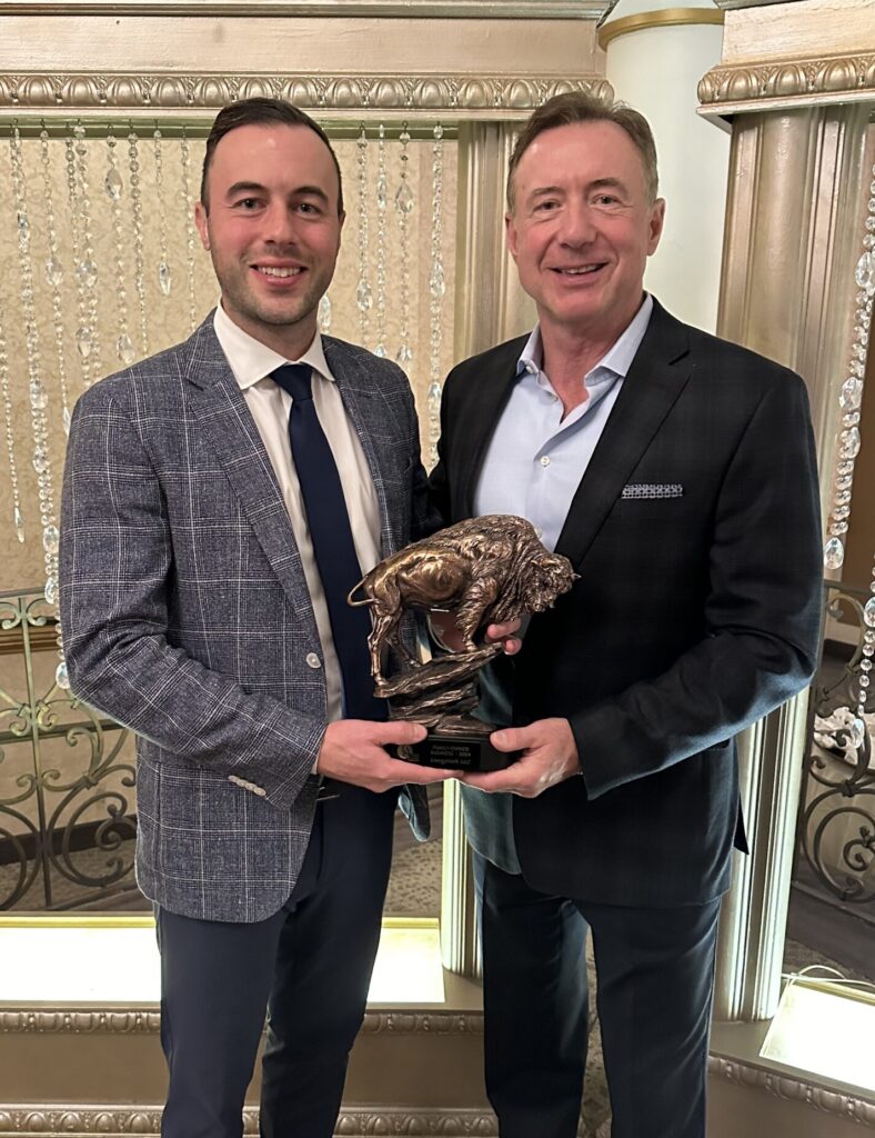 Luke Marchiori and Gary Marchiori holding an award shaped like a buffalo